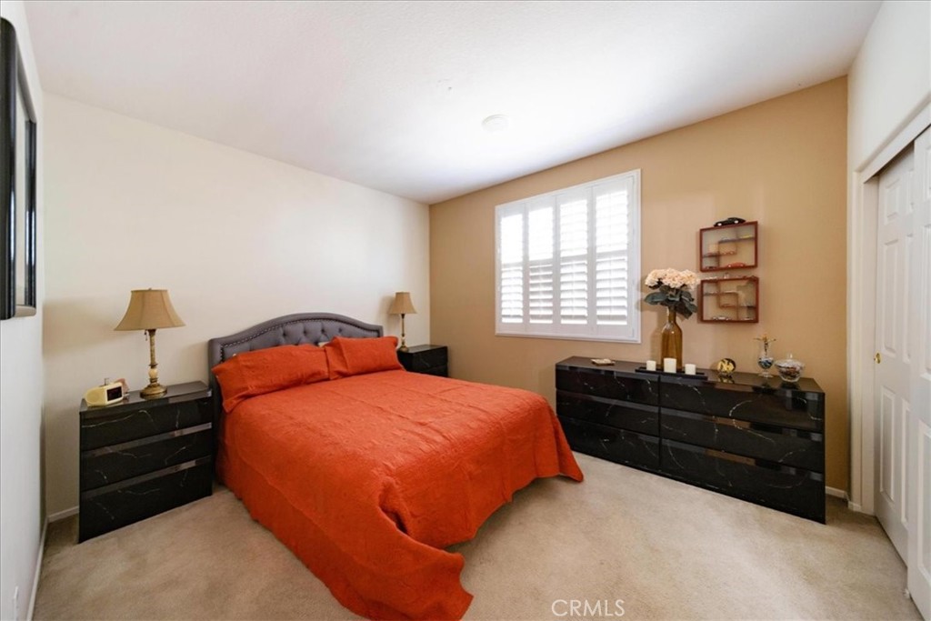 13449 Quail Run Road Eastvale, CA 92880 - Photo 33 of 59 a bedroom with a bed and dresser with window