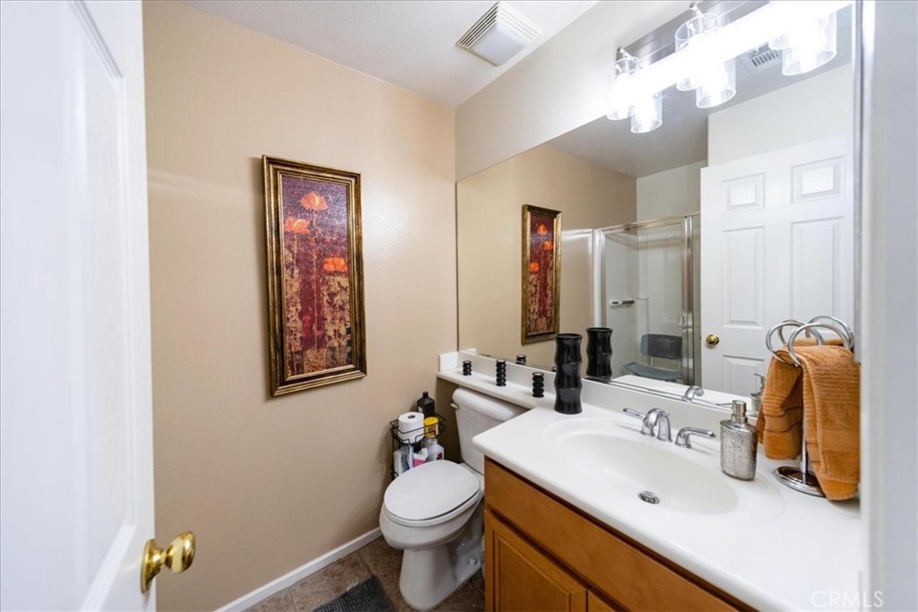 13449 Quail Run Road Eastvale, CA 92880 - Photo 35 of 59 a bathroom with a sink vanity mirror and toilet