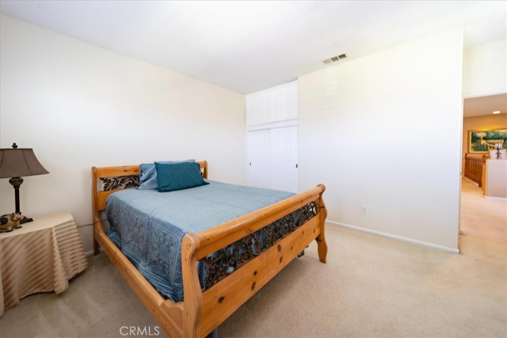 13449 Quail Run Road Eastvale, CA 92880 - Photo 41 of 59 a bedroom with a bed and a lamp on the dresser