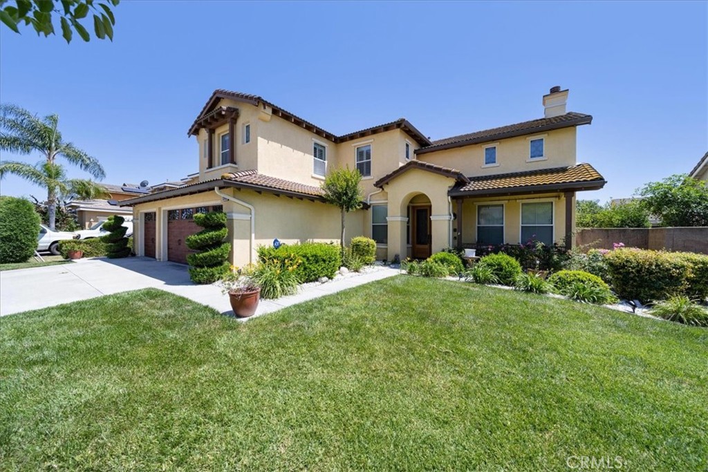 13449 Quail Run Road Eastvale, CA 92880 - Photo 7 of 59 a front view of a house with a yard and garage