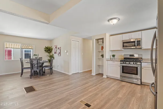 a kitchen with granite countertop a stove a sink and a refrigerator