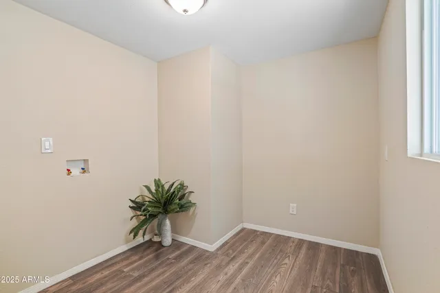 a view of a hallway with wooden floor and a window