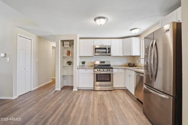 a kitchen with white cabinets and stainless steel appliances