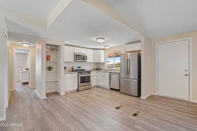 a kitchen with white cabinets and stainless steel appliances