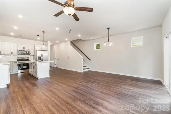 a view of a kitchen with wooden floor and stainless steel appliances