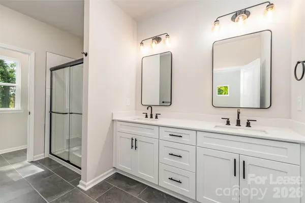 a bathroom with double vanity sinks and a mirror