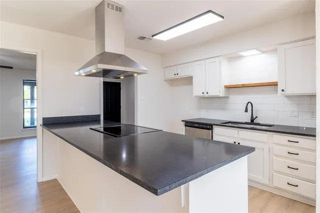 a kitchen with stainless steel appliances granite countertop a sink a stove and a refrigerator