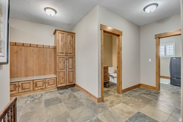 896 West 675 South Mapleton, UT 84664 - Photo 55 of 77 Mudroom featuring a textured ceiling, washer / clothes dryer, and stone tile flooring