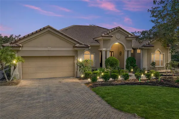 a front view of a house with a garden and plants