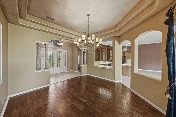 a view of a room with wooden floor fan and windows