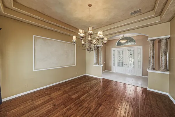 a view of an empty room with window and wooden floor