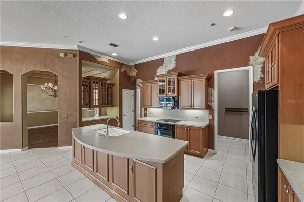 a view of an empty room with window and chandelier