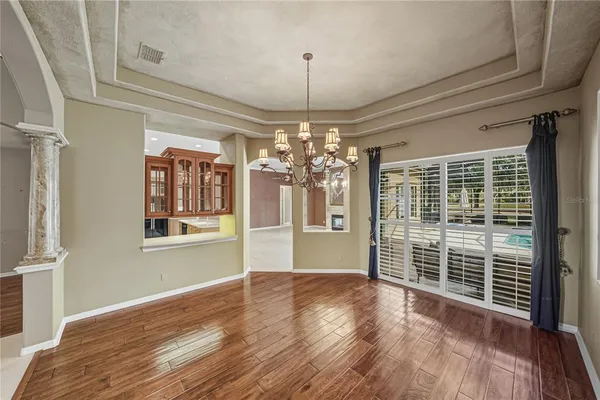a view of a big room with wooden floor and chandelier