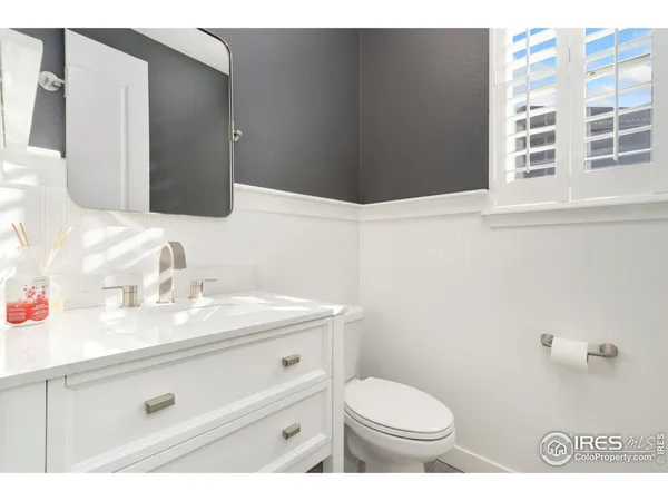 a bathroom with a granite countertop sink toilet and mirror