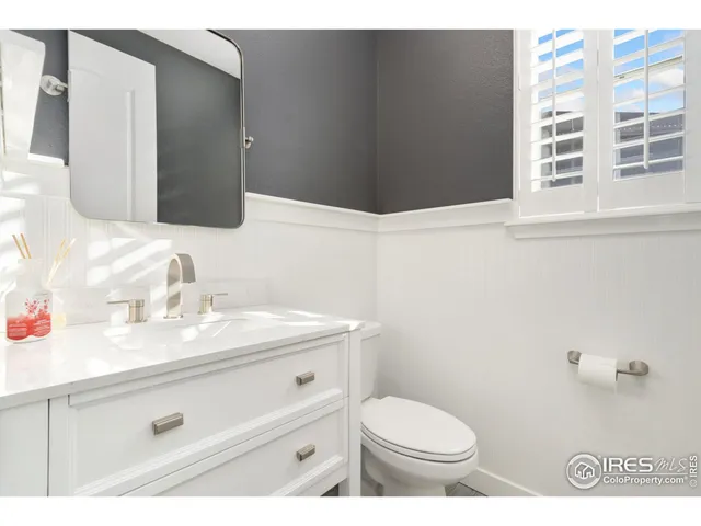a bathroom with a granite countertop sink toilet and mirror
