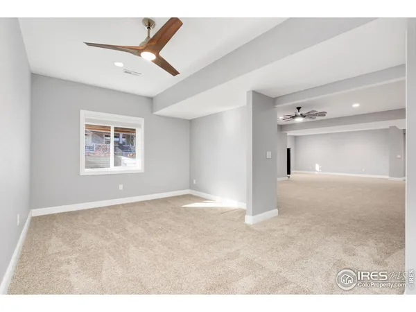 a view of a big room with windows and ceiling fan
