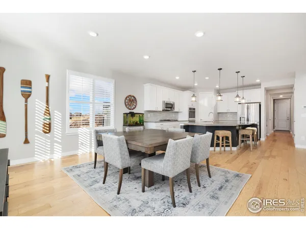 a living room with stainless steel appliances kitchen island granite countertop furniture and a wooden floor