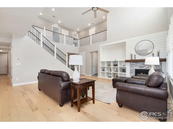 a living room with fireplace furniture and a large window