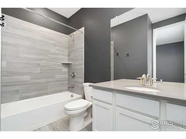 a bathroom with a sink toilet vanity and tub
