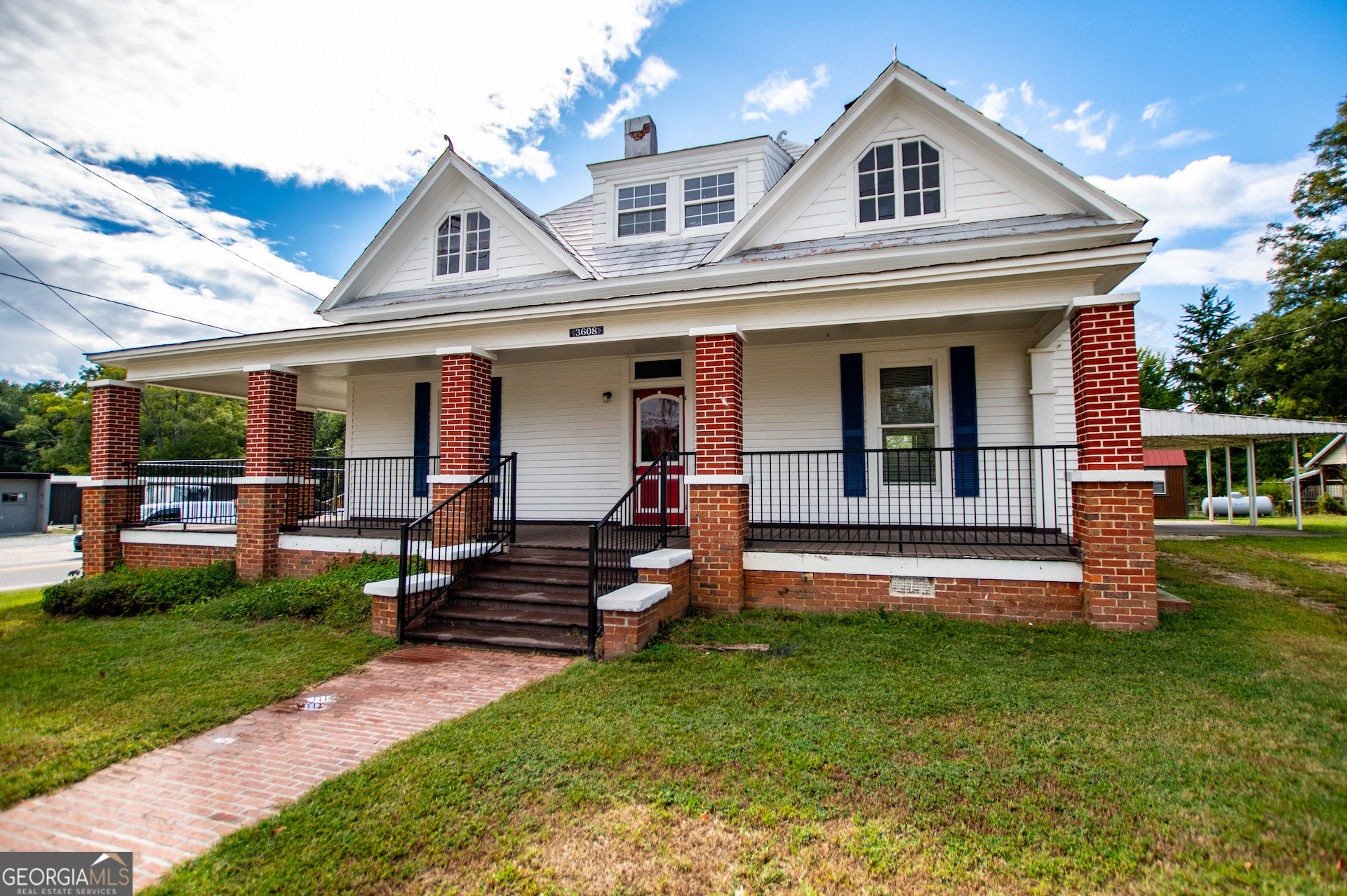 a view of a house with a yard and sitting area