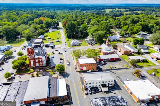a view of a swimming pool with a lawn chairs and a small yard