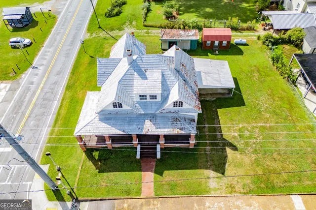 a view of a house with backyard and a tree