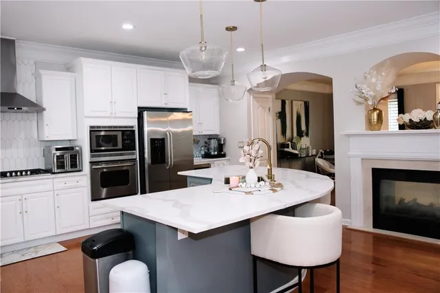 a kitchen with granite countertop a sink stainless steel appliances and dining table
