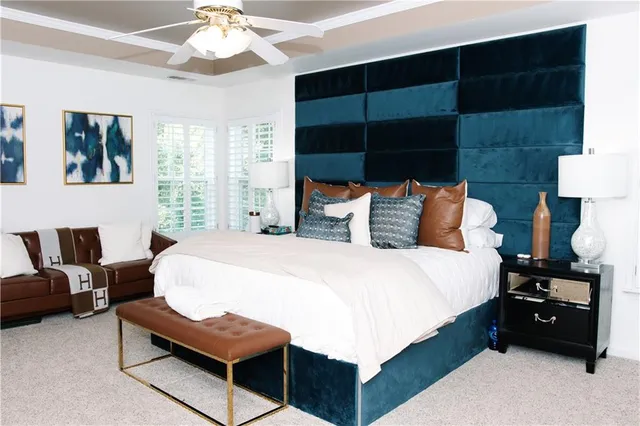 a bedroom with a bed a couch and a large window