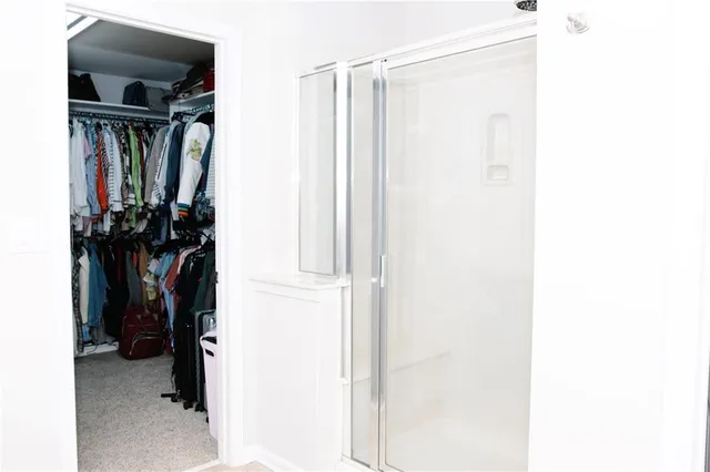 a view of walk in closet with clothes and shoes