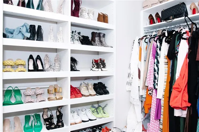 a view of walk in closet with clothes and shoes