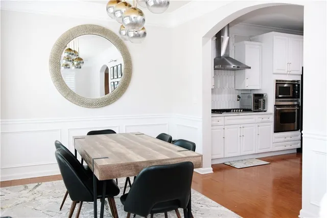 a kitchen with a table chairs a stove and a microwave