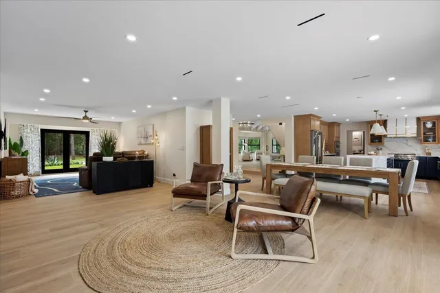 a large white kitchen with sink a stove a dining table and chairs