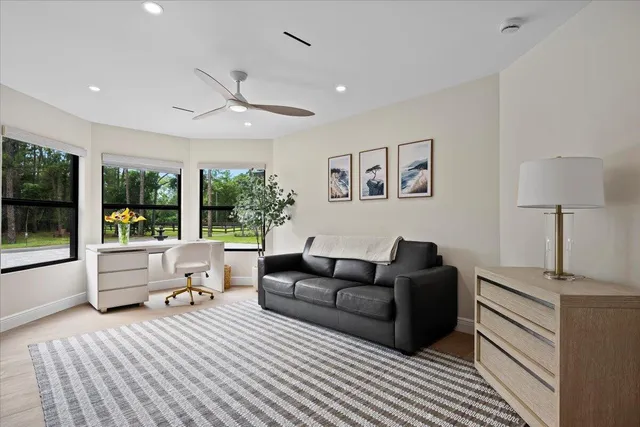 a living room with stainless steel appliances kitchen island furniture and a large window