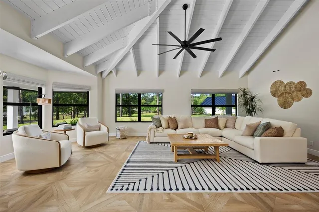a large white kitchen with sink a stove a dining table and chairs