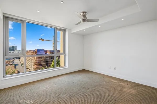 a view of empty room with wooden floor and floor to ceiling window