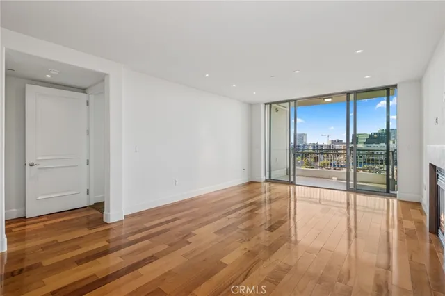 an empty room with a fireplace and wooden floor