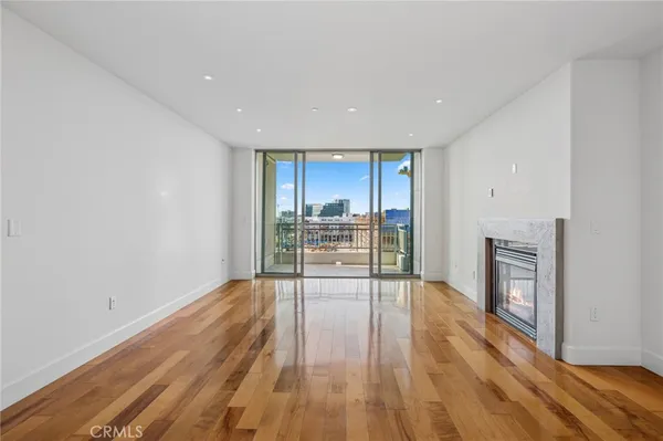 a view of empty room with wooden floor and fireplace