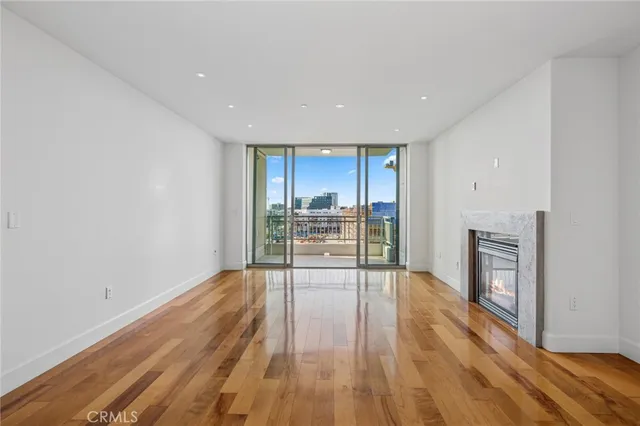a view of empty room with wooden floor and fireplace
