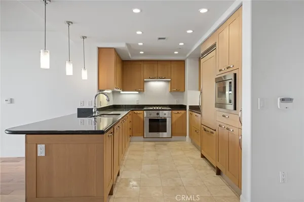 a kitchen with stainless steel appliances granite countertop a sink a stove and a refrigerator