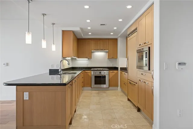 a kitchen with stainless steel appliances granite countertop a sink a stove and a refrigerator