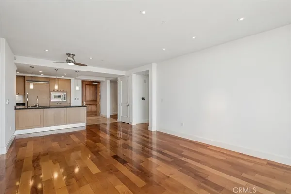 a large kitchen with granite countertop a sink and white cabinets
