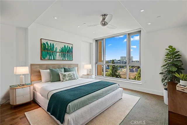 a bedroom with a large bed and a potted plant