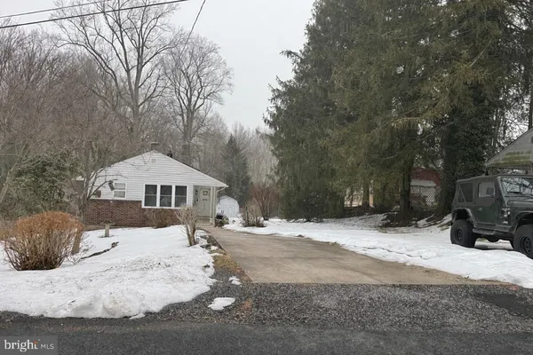 a view of a white house with a yard covered in snow