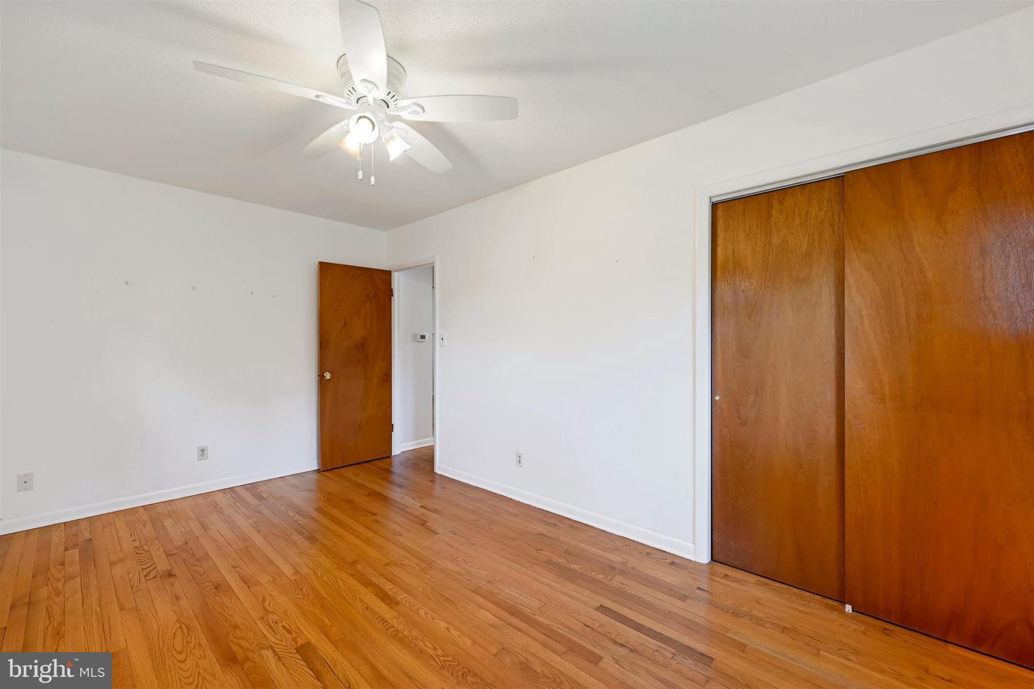 2926 Knoll Acres Drive Baltimore, MD 21234 - Photo 17 of 49 an empty room with wooden floor and fan