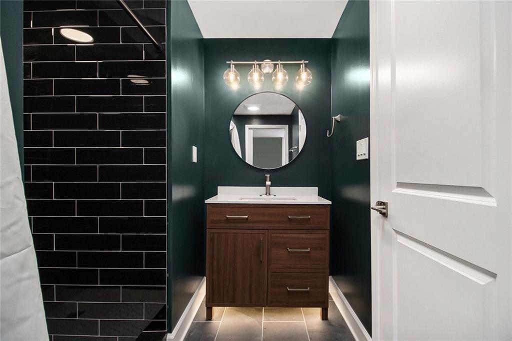 1723 Capistrana Place Decatur, GA 30032 - Photo 19 of 28 a bathroom with a double vanity sink a mirror and a shower