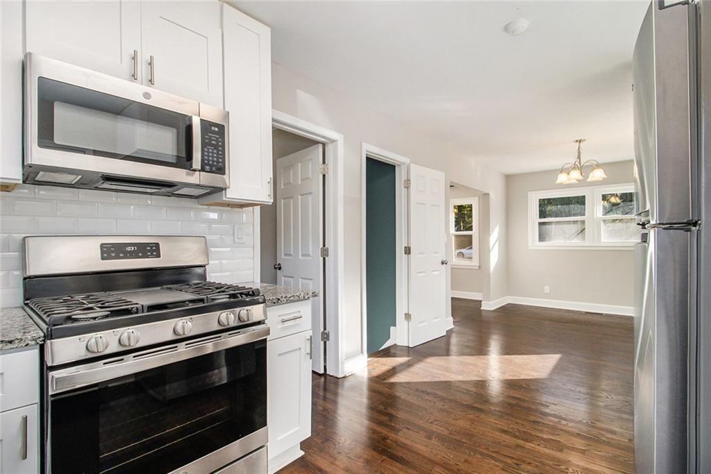 1723 Capistrana Place Decatur, GA 30032 - Photo 10 of 28 a kitchen with stainless steel appliances a stove a microwave and white cabinets