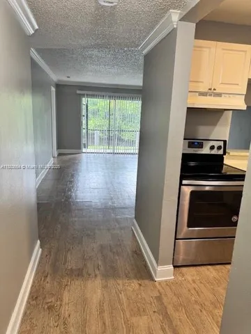 a kitchen with a stove wooden floor and a window