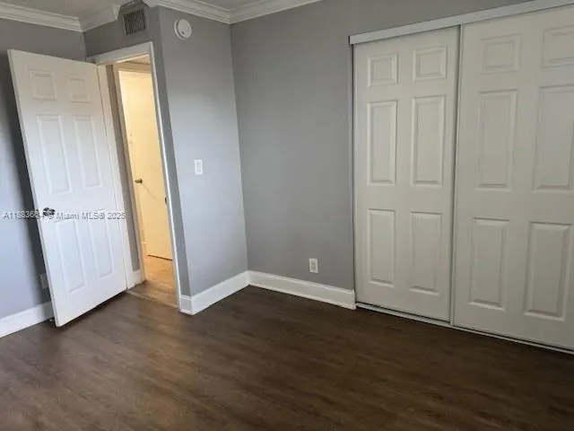 an empty room with wooden floor and window