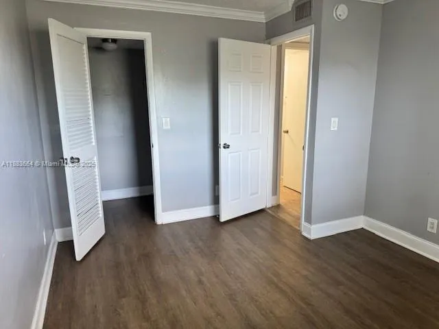 an empty room with wooden floor and closet