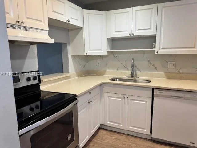 a kitchen with a sink stove and cabinets